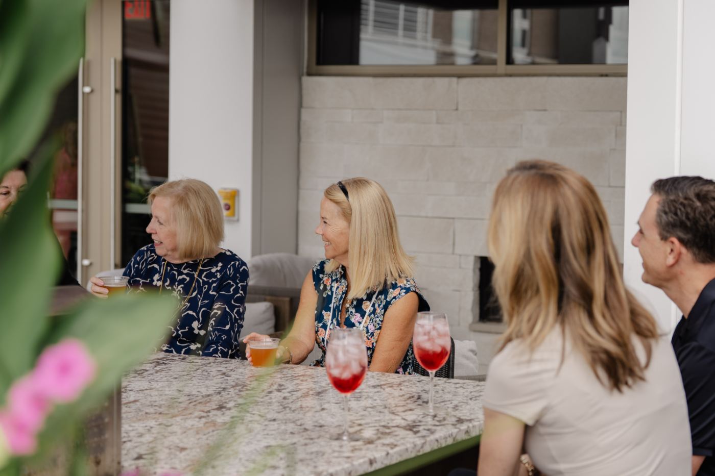 Residents talking over drinks by the fireplace lounge