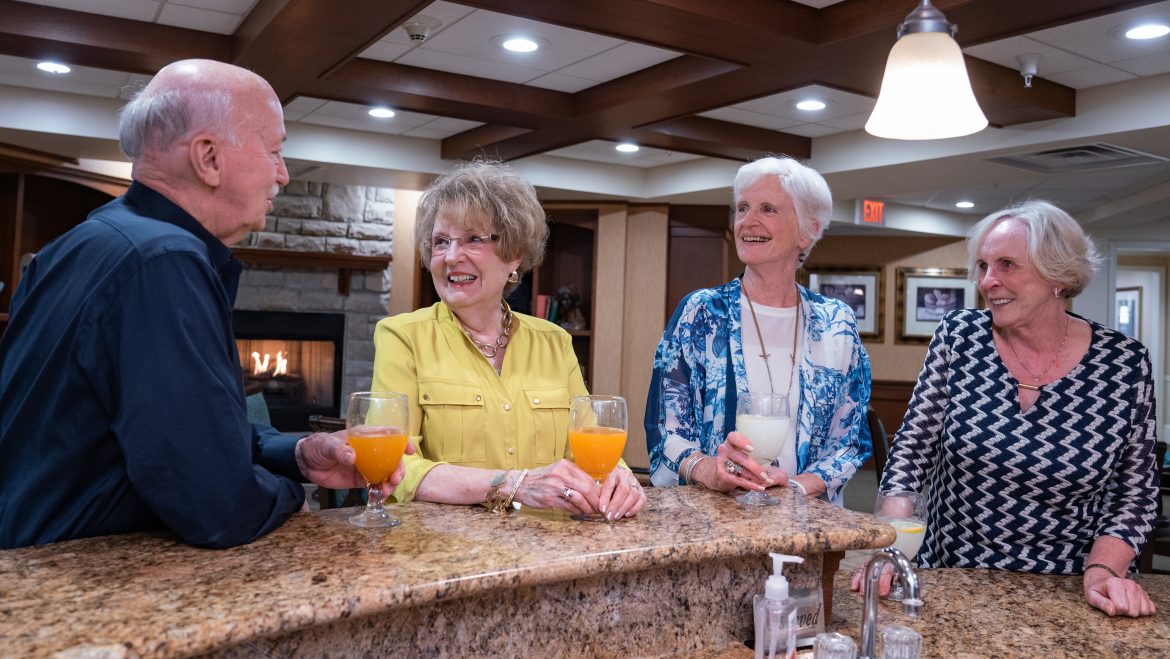 Residents socializing over drinks by the fireplace