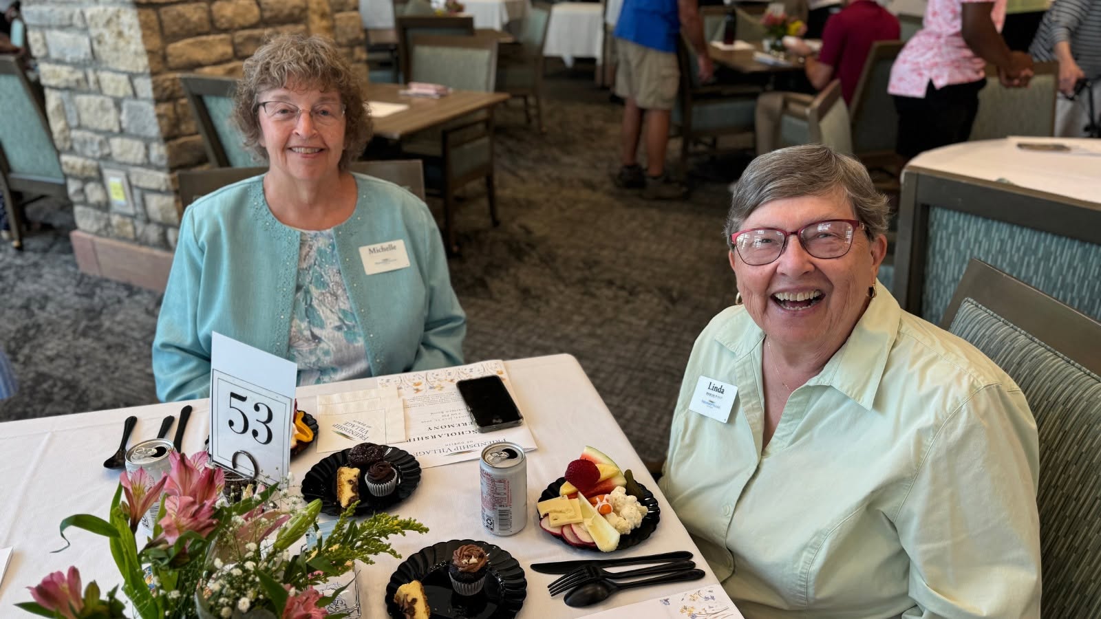 Two friends laughing over lunch